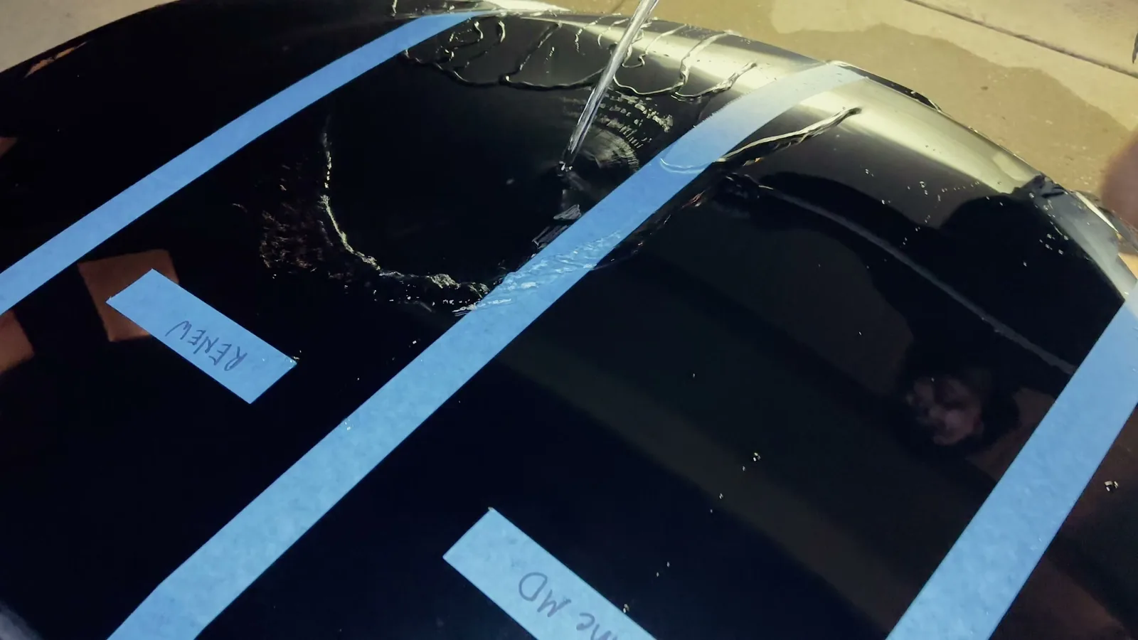 Water poured across a masked black hood comparing hydrophobicity between labeled Renew and ShineMD sections