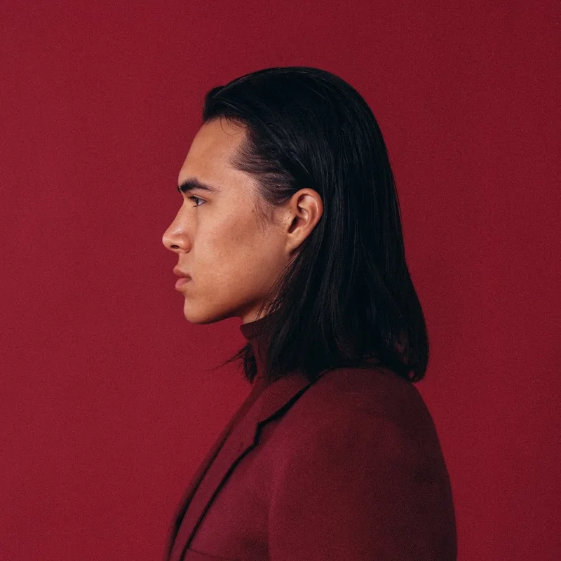 Profile portrait of Coy White in side profile against a deep red backdrop